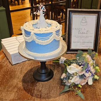 Blue and white vintage wedding cake with a bride and groom topper and a bouquet