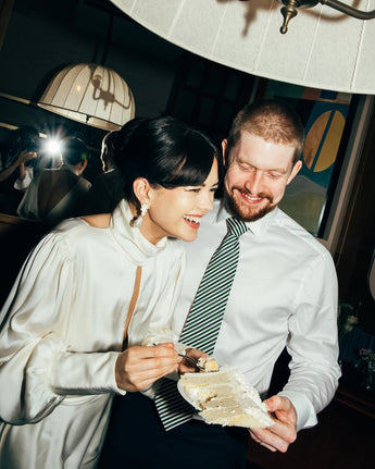 A bride and groom sharing a slice of wedding cake