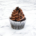 Chocolate Cupcake with chocolate buttercream, chocolate drizzle and crumbs, on a marble surface
