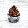 Chocolate Cupcake with chocolate buttercream, chocolate drizzle and crumbs, on a marble surface