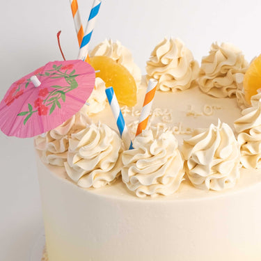 Cocktail Cake with buttercream rosettes, pineapple, paper straws and a cocktail umbrella, with a 40th message