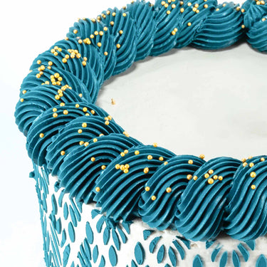 8 inch Stencil Cake with a teal stencilled leaf design, buttercream swirls and gold pearls