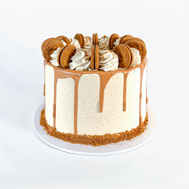 Lotus Biscoff Cake with caramel drip, piped swirls and whole Biscoff biscuits, with biscuit crumb around the base