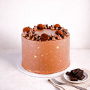 Triple Chocolate Cake topped with chocolate truffles, buttercream swirls and gold splatters, next to squares of dark chocolate