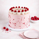 Raspberry White Chocolate Cake with pink buttercream, fresh raspberries, rosettes and heart sprinkles