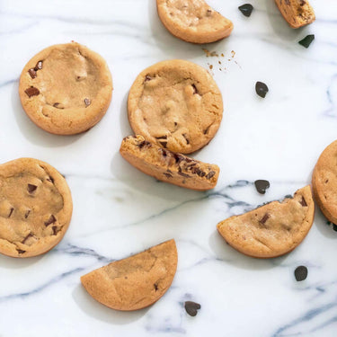 Chocolate Chip Cookies, whole and broken, on marble