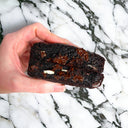Hand holding a Triple Chocolate Cookie broken in half