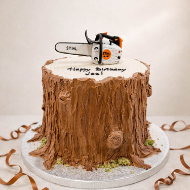 Tree stump cake with a sugar chainsaw on top
