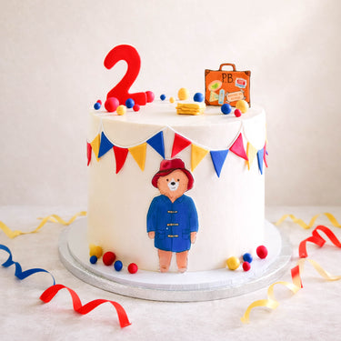 Paddington Bear second birthday cake with bunting and a suitcase