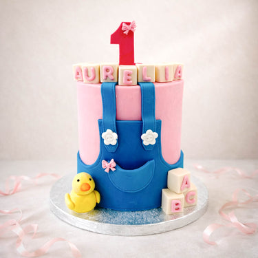 First birthday cake with dungarees, a rubber duck and alphabet blocks