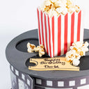 Movie Cake shaped like a film reel with a popcorn box and a fondant cinema ticket birthday message