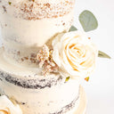 Naked Wedding Cake with an ivory rose, pale pink berries and eucalyptus