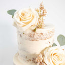 Two tier Naked Wedding Cake with ivory buttercream, cream roses, blush pink berries and eucalyptus