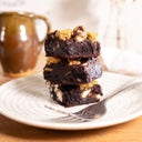 Stack of S'mores Brownies with marshmallows and biscuit pieces on a plate