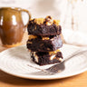 Stack of S'mores Brownies with marshmallows and biscuit pieces on a plate