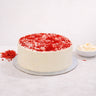Red Velvet Cake with smooth white buttercream and red velvet crumbs on a silver board