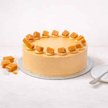 Salted Caramel Cake with smooth buttercream and caramel pieces on a silver board