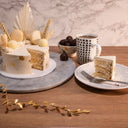 Mini Dried Grasses Cake with gold leaf, macarons and truffles, with a slice on a plate and a mug