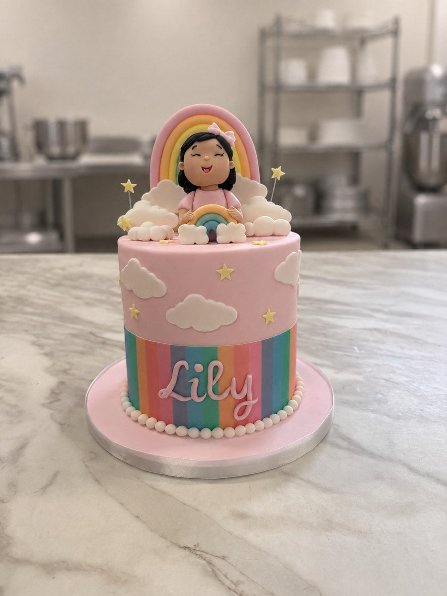 Pink rainbow birthday cake with clouds, stars, pastel stripes, a sugar girl topper holding a rainbow and Lily in pink script