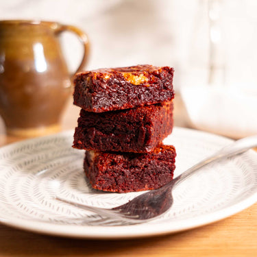 Stack of three fudgy chocolate brownies on a plate