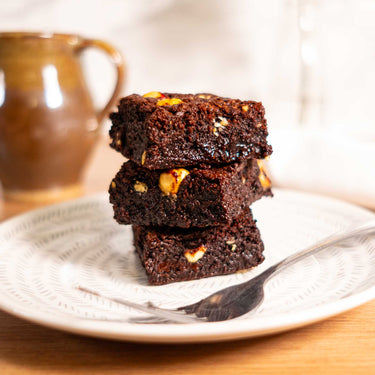 Stack of brownies with white chocolate chips on a patterned plate