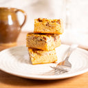 Three blondies with nuts and swirls on a patterned plate