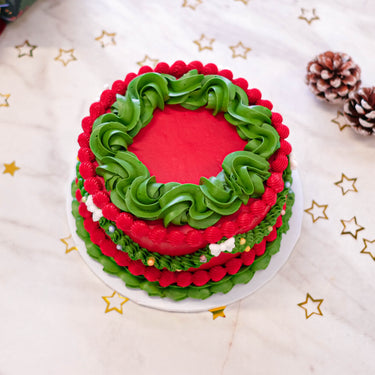 Frilly Christmas Cake with red and green buttercream swirls, with pine cones and gold stars