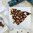 Brownie Christmas Tree topped with buttercream stars and gold sprinkles, with slices on a plate