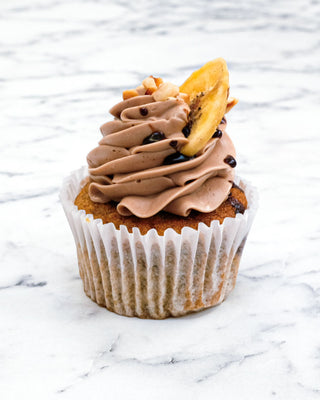 Banana, Chocolate and Hazelnut Cupcake with Nutella buttercream, chopped hazelnuts, a banana chip and chocolate drizzle