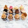 Box of 12 Mixed Cupcakes in different flavours, with buttercream swirls, biscuit pieces and chocolate shards