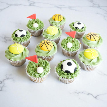 12 Sports Cupcakes with green buttercream grass and fondant footballs, basketballs, tennis balls and golf flags