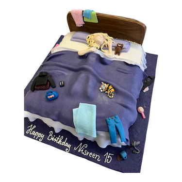 Custom birthday cake designed as a bed, with a fondant figure and accessories