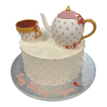 Custom birthday cake with a fondant teapot and teacup and peach polka dots