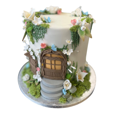 Custom fairy door cake with fondant greenery, flowers and butterflies