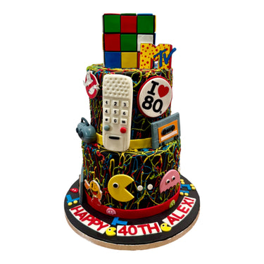 Custom three tier 80s themed cake with a Rubik's Cube and retro arcade decorations