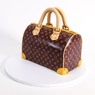Handbag Cake designed as a monogram holdall bag with gold details and realistic handles