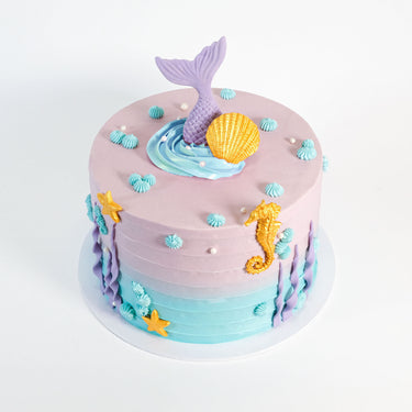 Mermaid Cake with lilac to aqua buttercream, a mermaid tail, gold sea decorations and buttercream bubbles