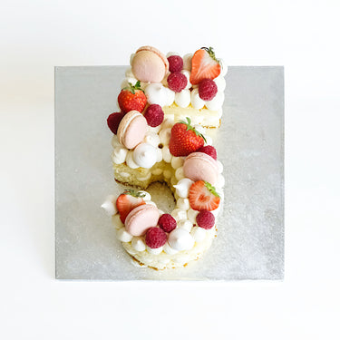 Number Cake with vanilla cream, pink macarons, meringue kisses, strawberries and raspberries