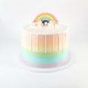 Tall Rainbow Cake with pastel rainbow stripes, white drip and a fondant rainbow with buttercream clouds