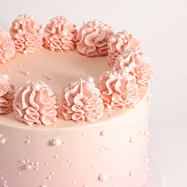 Free From Ombré Cake with pink buttercream, piped rosettes and sugar pearls