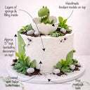 Free From Baby Dino Cake with white and green buttercream, chocolate crumb soil, fondant stones and a hatching dinosaur