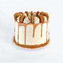 Lotus Biscoff Cake with caramel drip, piped swirls and whole Biscoff biscuits, with biscuit crumb around the base
