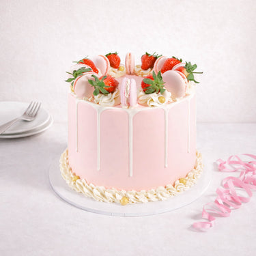Strawberry Macaroon Cake with pink buttercream, white drip, fresh strawberries, macarons and gold pearls