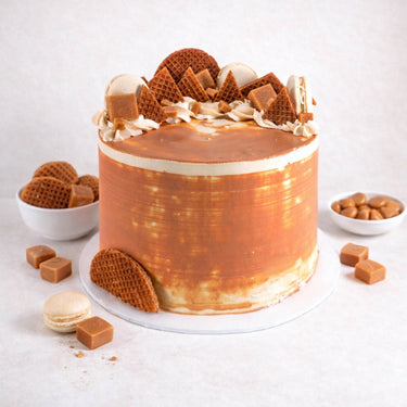 Salted Caramel Cake with caramel buttercream, stroopwafels, fudge and vanilla macarons on top