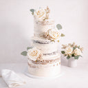 Three tier Naked Wedding Cake with a semi naked buttercream finish, ivory roses and eucalyptus