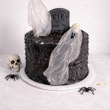 Tombstone Cake with black buttercream, ghost figures, a fondant tombstone, skulls and spiders