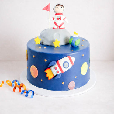 Space Cake with blue fondant, stars, planets, a 3D rocket and an astronaut on the moon