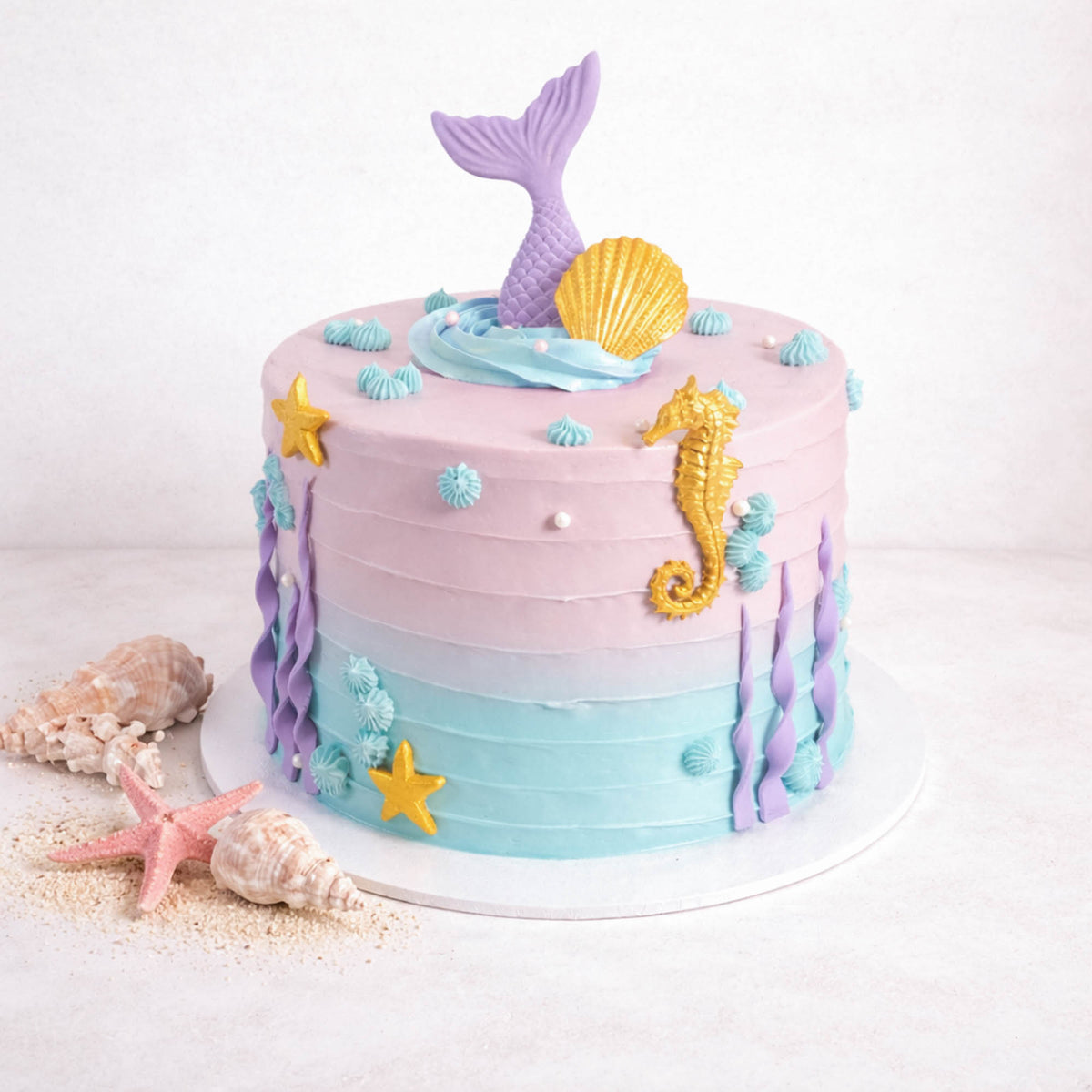 Free From Mermaid Cake with ombre buttercream, a mermaid tail, gold shells and a seahorse