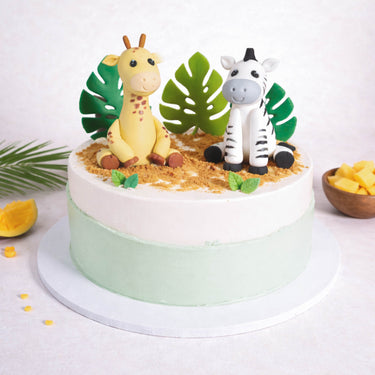 Mini Safari Cake with mint and ivory buttercream, a fondant giraffe and zebra, edible sand and leaves