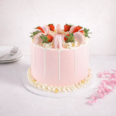 Gluten friendly Free From Strawberry Macaroon Cake with pink buttercream, white drip, strawberries and macarons